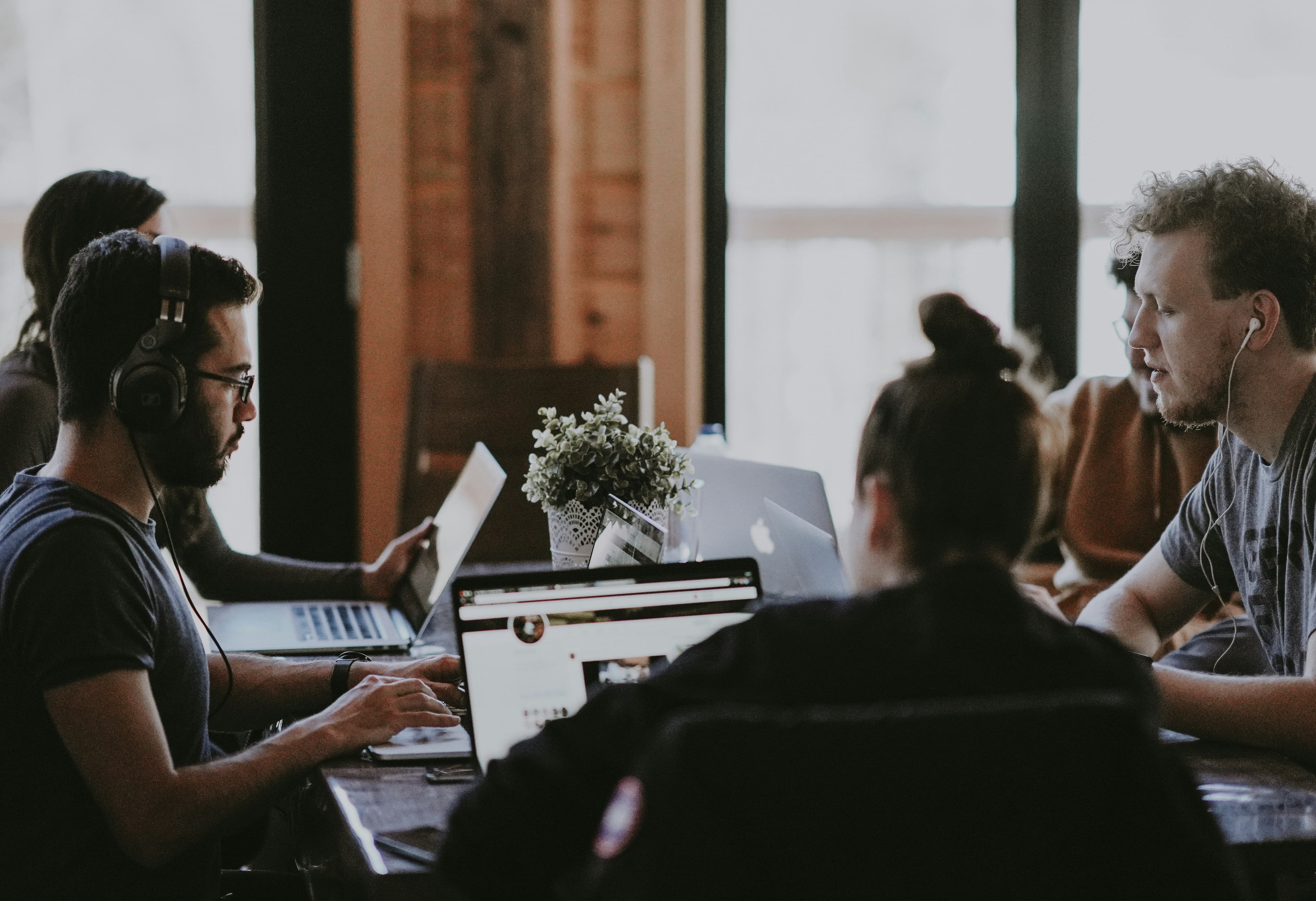 A team working side by side on laptops at a long shared table